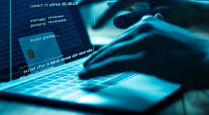 Online scams hands typing on keyboard